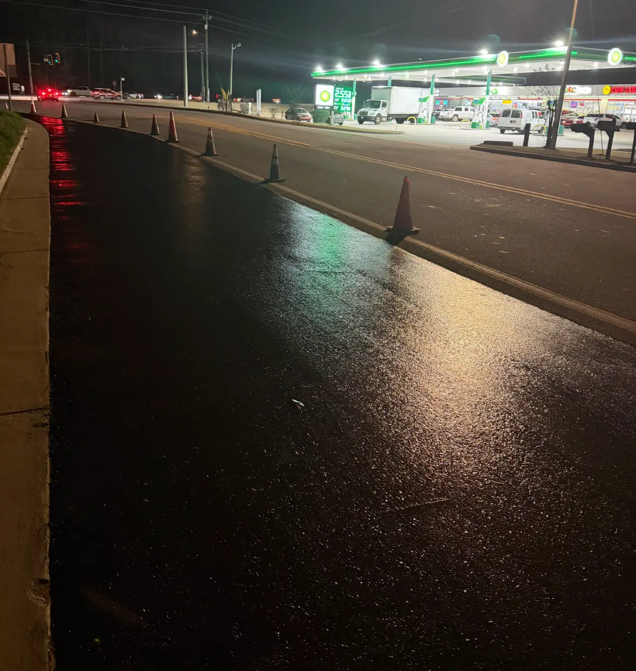Freshly sealcoated commercial parking lot outside a BP gas station at night